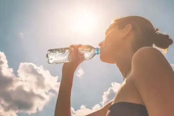 Hydration: The Secret Ingredient for a Toned Stomach and Enhanced Fitness 3 Image of woman drinking water to hydrate Walton on the Hill after run.